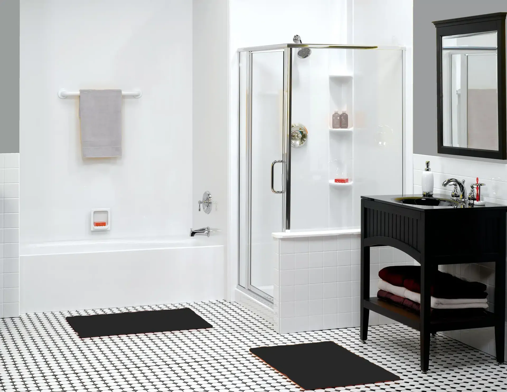 Modern bathroom with black vanity, white subway tile walls, glass shower enclosure with built-in shelving, and black and white mosaic floor tiles